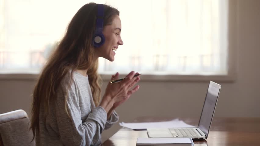 Happy female online teacher interpreter wearing headphone, smiling young woman student study with laptop talking with tutor, distance education and e learning concept