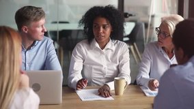 African ethnicity businesswoman negotiating with company partners clients sitting at table in boardroom multiracial team leader reporting telling about sales stats to diverse colleagues during meeting - Powered by Shutterstock - Get 15% off with code: PIKWIZARD15