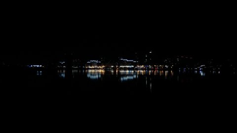 Panoramic view of the city. Dark night. Traffic in the night city. Reflection of skyscrapers and buildings in the city pond. Luxurious rich life in the city.