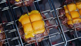 Clip of Hamburger patties on barbecue grill with melting cheese on top. close up view in 4k