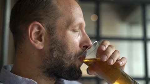 Young man drinking beer in cafe