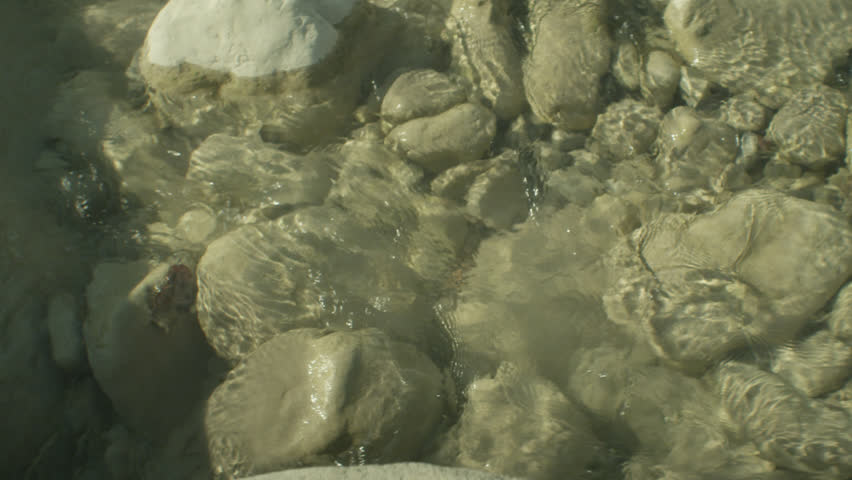 
Stream in slow motion. Water slowly flows among the stones. Clear water. 
Gray stones. Camera Arri Alexa/Prores4444
