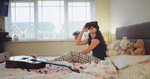 Charismatic teenager girl using a virtual reality glasses on her bedroom,very enthusiastic she exploring the virtual world