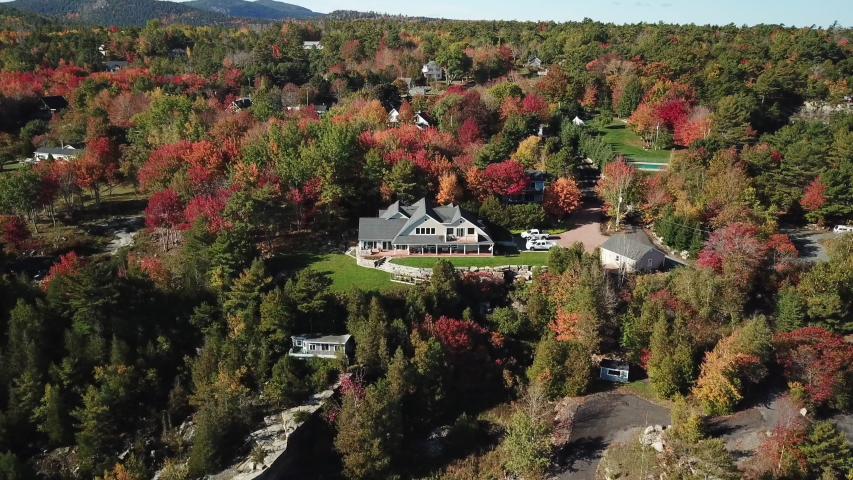A Large Home Nestled in the Colorful Autum Trees of Acadia National Park in Maine, Aerial View with Forward Motion