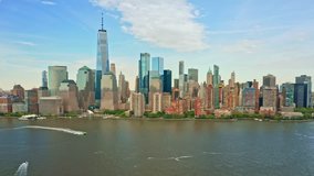 Aerial drone footage of downtown New York skyline. The camera moves towards the Lower Manhatttan skyline while a speedboat is crossing the frame