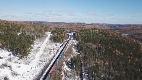 Winter day Aerial drone follow Trans-Siberian railway passengers tourist train near Baikal lake. Cinematic professional footage. High altitude