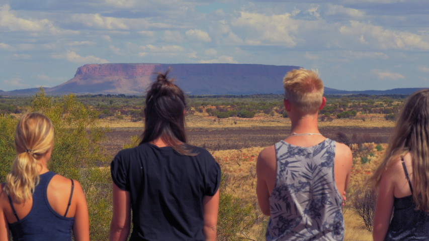 Group of friends enjoying view of Mount Conner with semi cloudy sky and sunny view.