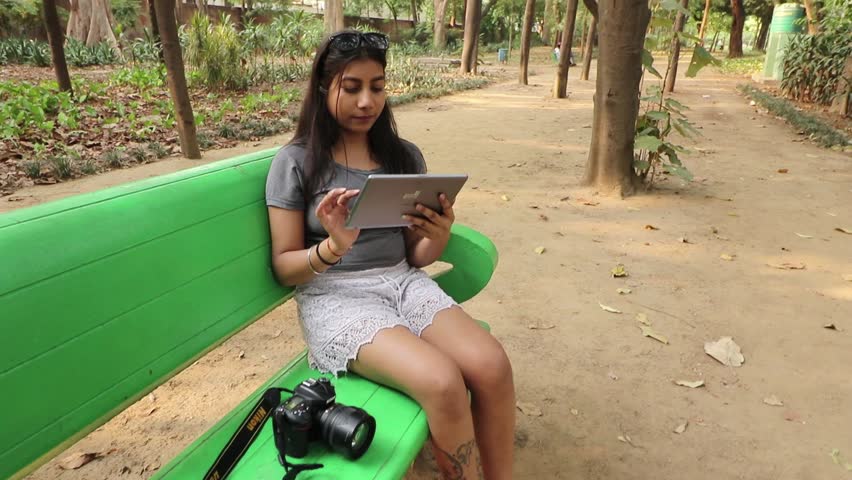 A young girl using a tablet and taking photos at a park in New Delhi, India on 12.05.2019. 