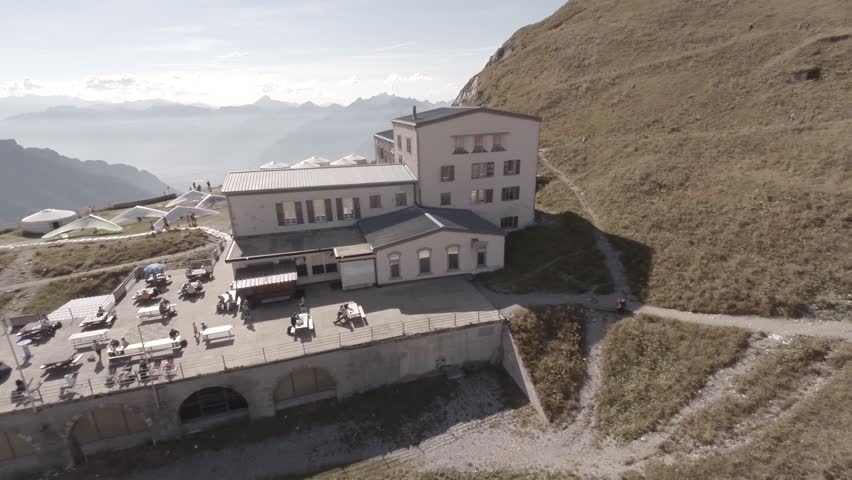 Flying by a mountain top restaurant with sky gliders