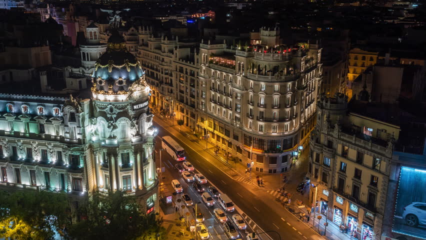 Night time lapse view of architectural landmark Metropolis building and traffic on Gran Via street in central Madrid, Spain. Royalty-Free Stock Footage #1029384632