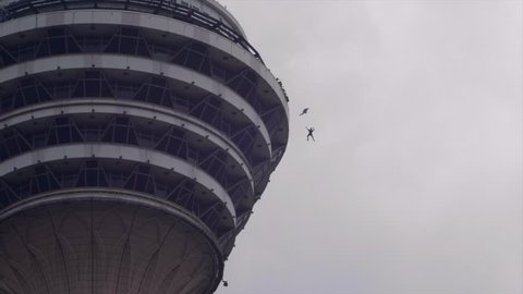 Kuala Lumpur, Malaysia - 09 29 2018: Base jumpers jumping from Menara tower in Kuala Lumpur.