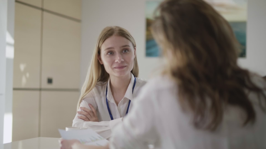 Cheerful female managers chatting. Two young business ladies enjoying easy talk during break at office