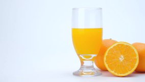 4k Slider shot of orange fruit and orange juice on white background.