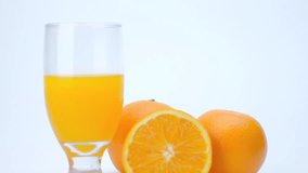 4k Zoom out shot of orange fruit and orange juice on white background.