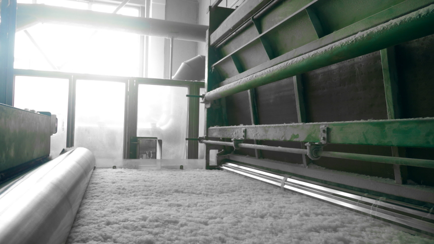 Polyester batting rolled on a factory conveyor.