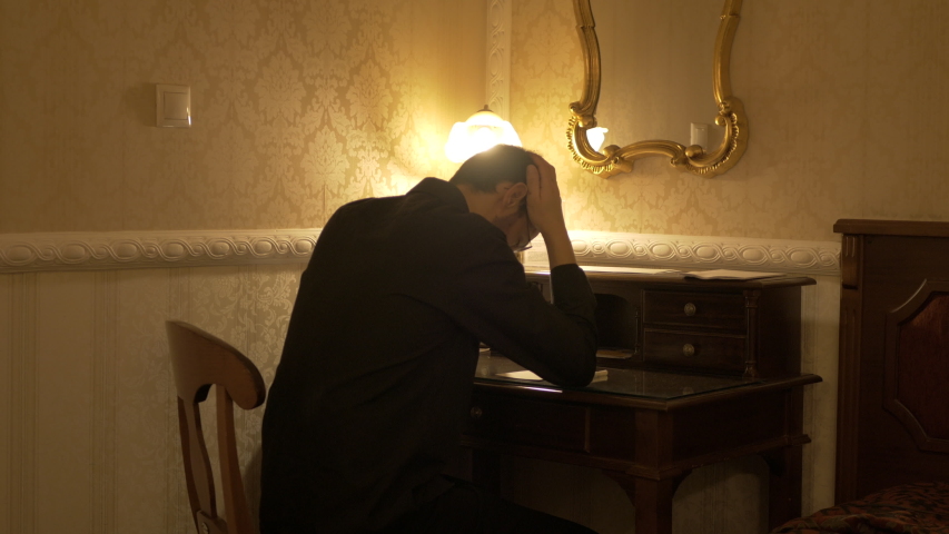 Man in black shirt read his notes put the notepad and pen in the drawer and decides to leave.