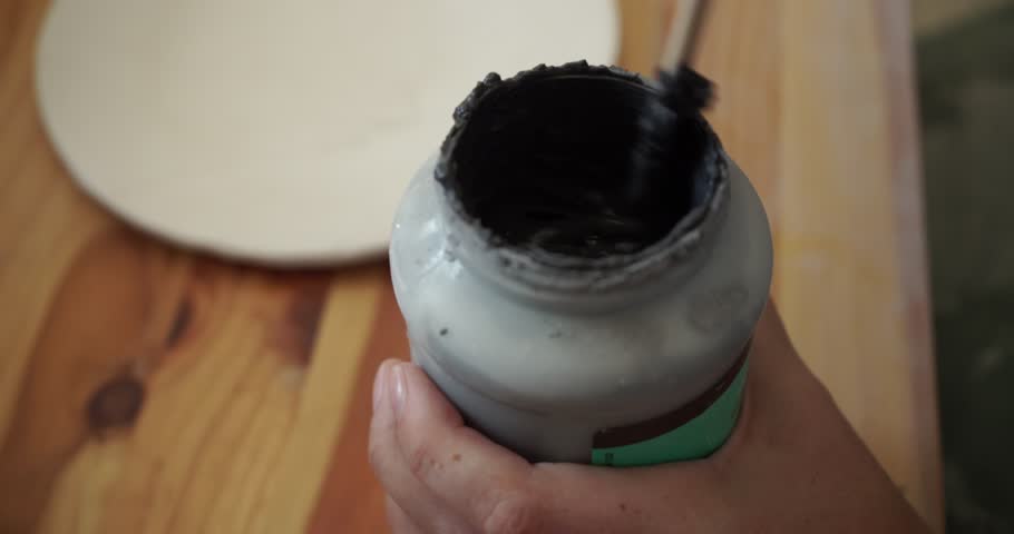 Close Up of Artist Mixing Paint in a Pot