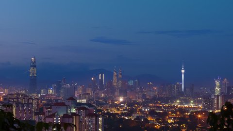 Time lapse: Beautiful and dramatic first light sunrise view of Kuala Lumpur city skyline from afar and high angle in Malaysia.