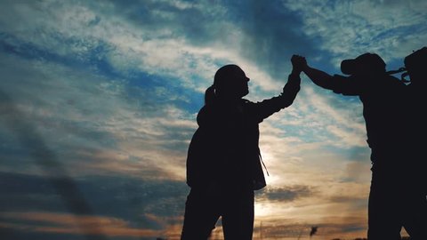 teamwork hands. business journey concept win. happy family team tourists man and woman sunset silhouette help shake teamwork hands victory success lifestyle . slow motion video. tourism husband top