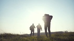 teamwork help business travel silhouette concept. group hikers of people slow motion video walking in a field on trekking trip. tourists with backpacks traveling. happy family lifestyle teamwork