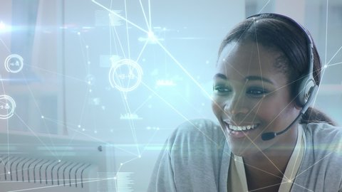 Close up of an African-american female call centre agent talking on her headset. Digital animation of lines and graphs are running in the foreground