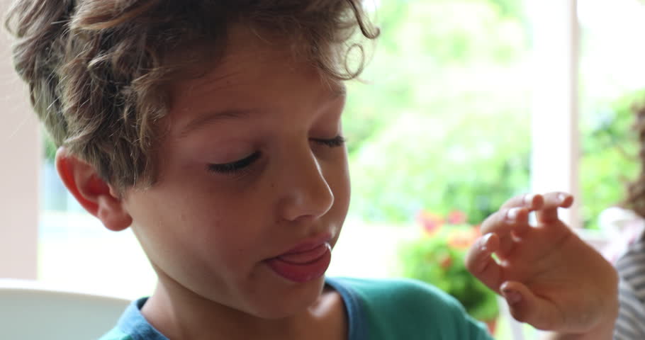Little boy doing digust face and funny grimace and then taking a bite from food Royalty-Free Stock Footage #1029424571