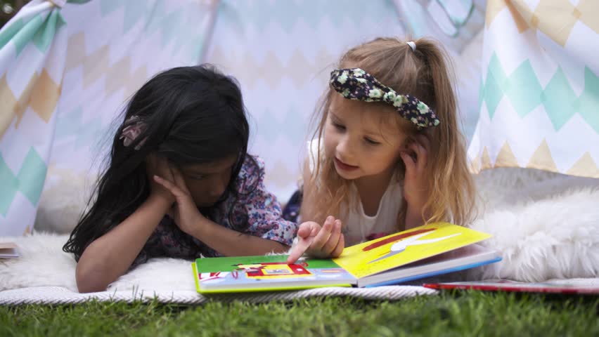 Happy Girls Reading Book In Kids Tent in Graden