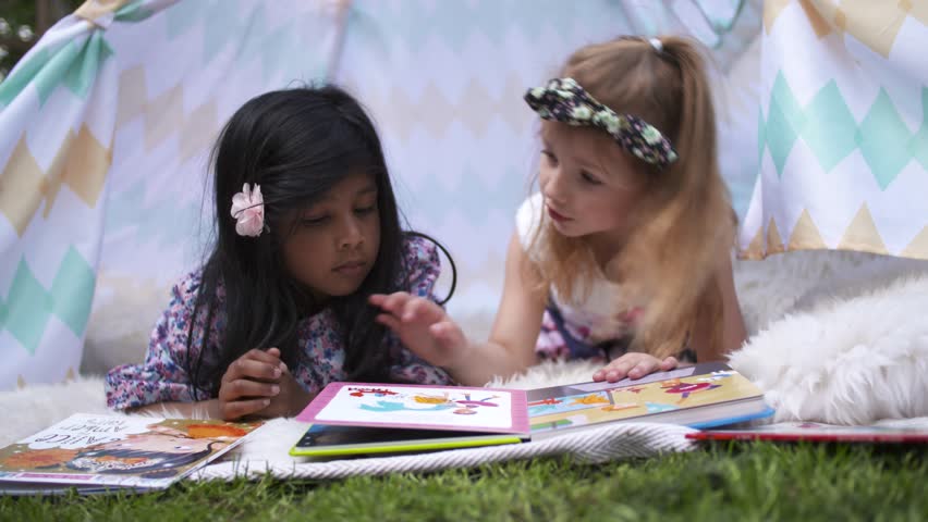 Happy Girls Reading Book In Kids Tent in Graden