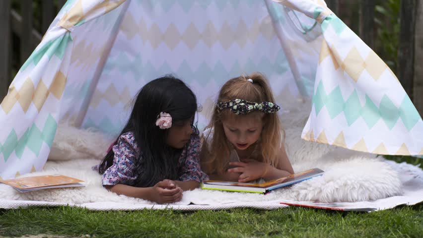 Happy Girls Reading Book In Kids Tent in Graden