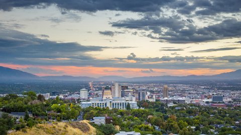 Day to night time-lapse video of Salt Lake City skyline panorama with famous Utah State Capitol on a beautiful summer day with dramatic moving cloudscape and slight zoom out effect, Utah, western USA