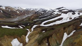 Drone aerial footage of Landmannalaugar surreal nature scenery landscape in highland of Iceland, Europe. Beautiful colorful snow mountain terrain famous for summer trekking adventure and outdoor.
