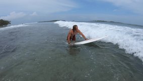 Set of five clips about young caucasian surfer riding the waves. Set contains clips with man passing the wave, paddling, diving under the wave, surfing and walking back from the water