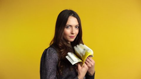 Carefree young woman counting euro banknotes and show stack of money in hand. Business, income success concept. Slow motion