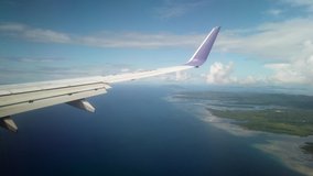 Airplane Flight. Wing of an Airplane Flying Above the Clouds. Beautiful Sulawesi Island a View From the Window of Airplane, Aircraft. Traveling by air. 4K UHD video