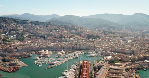 Aerial view of panorama of Genoa city center and industrial maritime port in a sunny day.
