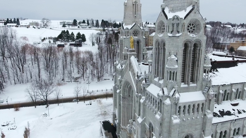 A big golden status is on the top of an old church in Quebec, Canada.