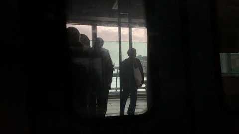 Silhouettes of commuters on the passing train in London