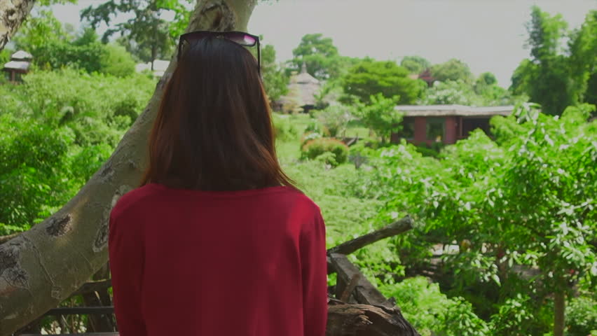 Asian Girl in red jacket taking picture by phone from the Tree house viewpoint