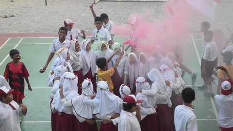 JAKARTA, INDONESIA, MAY 14, 2019 : students play on the school grounds, dance and hold smoke bombs. Back to school concept