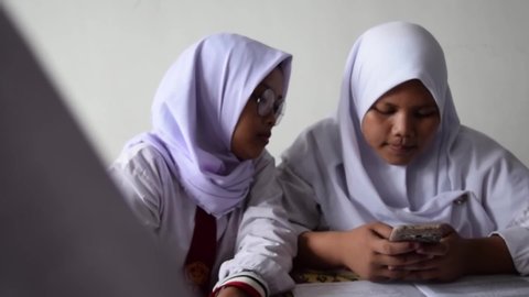 JAKARTA, INDONESIA, MAY 14, 2019 : Unrecornized people. Students play handphones and dance on the floor when teacheris not in class. Back to school concept