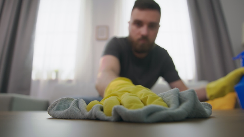 Man wipes dust on the coffee table