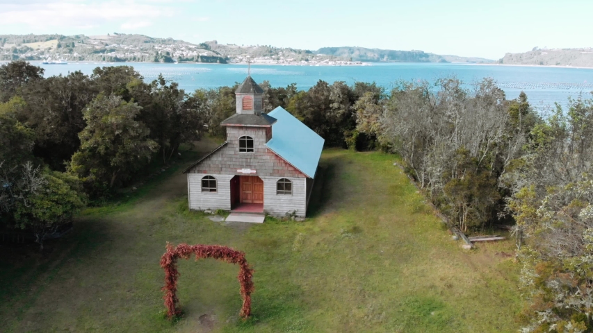 Small church on the shore of an island, garden decorated for a fall wedding. Aerial view, 4k.
