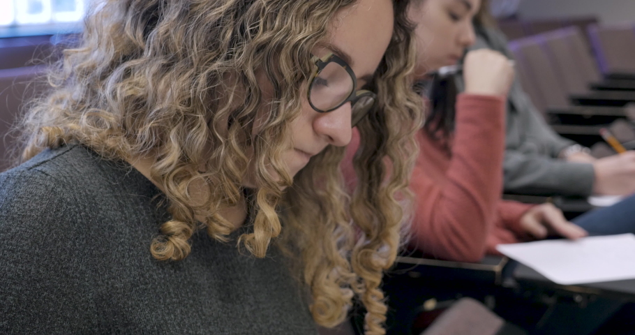 Stressed out female student trying to remember difficult answers to a test in a classroom Royalty-Free Stock Footage #1029494237