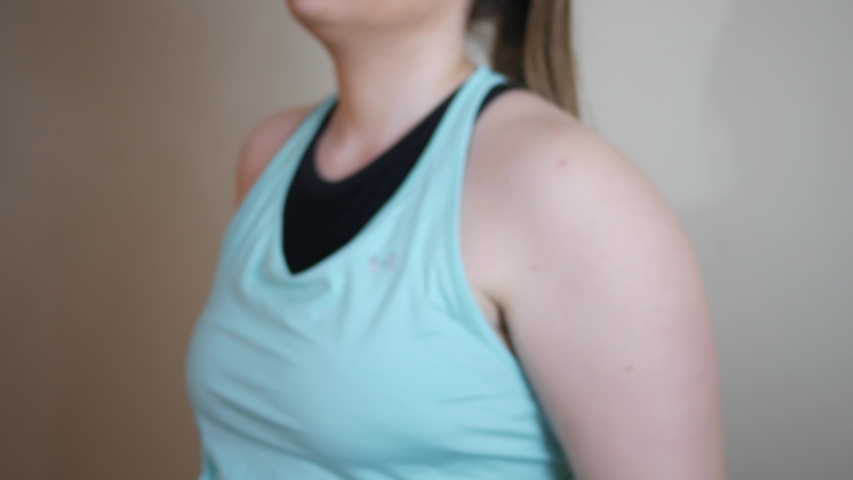 A Woman stretches her arms before a work out ALT
