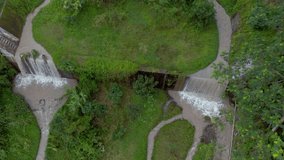 Aerial footage panning up view of brown step waterfall cascade dam