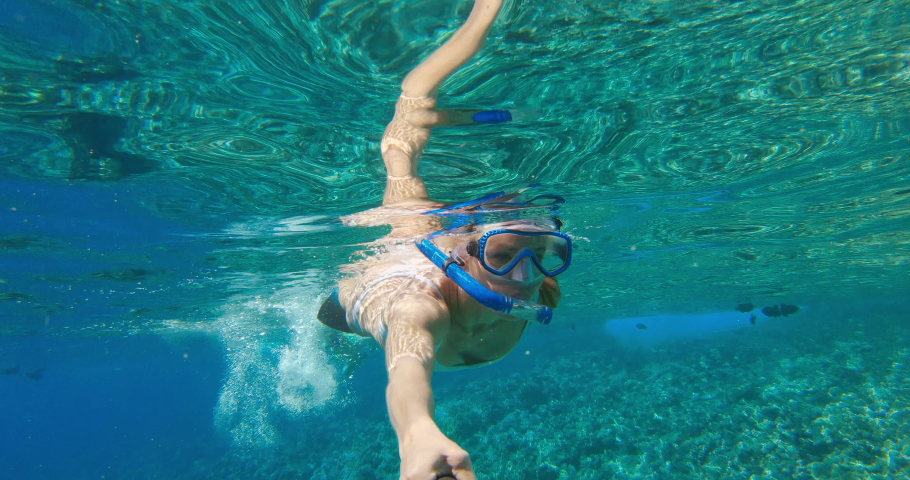 POV action cam shot of young attractive woman in bikini snorkeling in tropical ocean water with fish, summer vacation fun | Shutterstock HD Video #1029503393