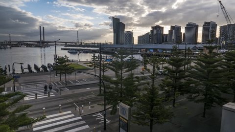 Melbourne, Australia, May14,2019: Panoramic Docklands view. Pedestrians, cars and trams flow along Harbour Esplanade. A Ferry lands near Central Pier. The Bolte Bridge is seen in the distance.