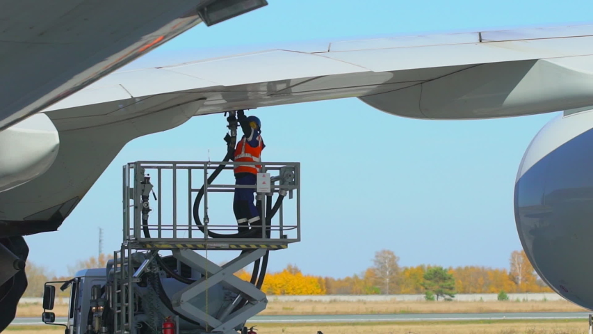 Airport airplane crew refueling aircraft on airline by technical staff maintenance ground. Preparing airplane for departure. repair of aircraft service worker use fuel hose on aircraft wing, on stairs Royalty-Free Stock Footage #1029508856