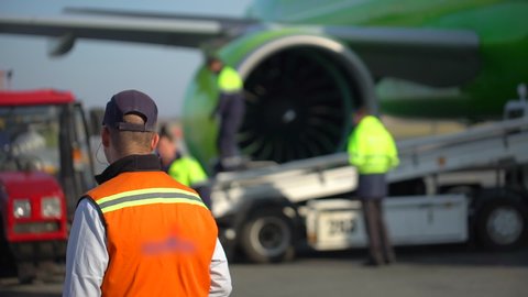 Airport airplane aircraft maintenance ground crew, mechanic, luggage loading on airline by workers technical staff. baggage on conveyor. Load luggage on plane, Suitcases traffic. Departures terminal