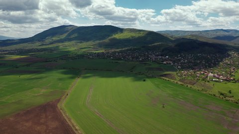 Aerial video of farm fields and mountain with clouds